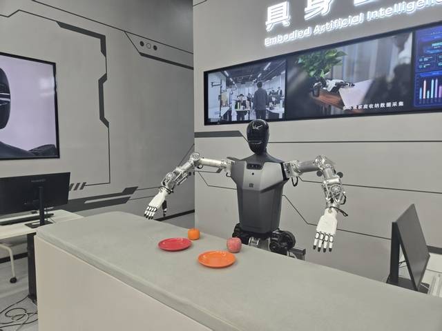 휴머노이드 로봇이 귤을 그릇 위에 놓는 모습.