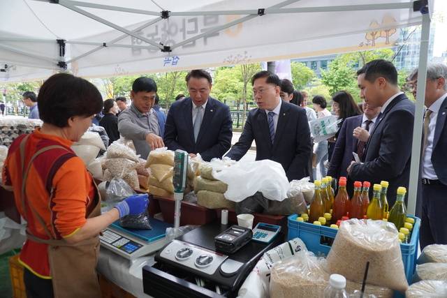 20일 열린 ‘행복예감 직거래장터’에서 유재훈 예금보험공사 사장(왼쪽 세번째)과 맹석인 서울농협본부장(〃 네번째)이 농민이 판매하는 잡곡을 구입하고 있다.