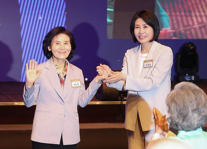 국민의힘 김문수 대선 후보의 부인 설난영 씨와 더불어민주당 이재명 대선 후보의 부인 김혜경 씨가 5월12일 서울 중구 신라호텔에서 열린 중앙신도회 창립 70주년 기념식에서 손을 맞잡고 있다. ⓒ연합뉴스