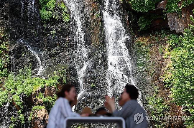 '진짜만큼 선명한' (서울=연합뉴스) 김도훈 기자 = 전국 대부분 낮 기온이 25도 이상을 기록하는 등 초여름 날씨를 보인 20일 서울 서대문구 홍제폭포 산책로에서 설치된 대형 거울에 폭포 모습이 비치고 있다. 2025.5.20 superdoo82@yna.co.kr