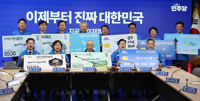 윤여준, 박찬대 더불어민주당 상임총괄선거대책위원장을 비롯한 선대위원장들이 21일 서울 여의도 더불어민주당 당사에서 열린 중앙선거대책위원회의 시작에 앞서 지역화폐 사용을 촉구하는 퍼포먼스를 하고 있다. /뉴시스