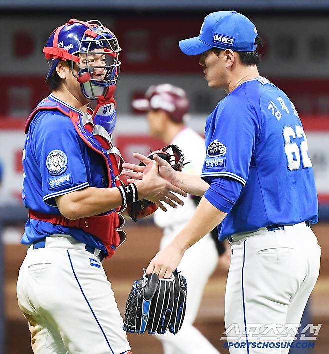 11회 내내 마스크를 쓴 강민호가 김재윤과 악수하고 있다.