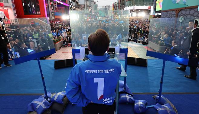 이재명 더불어민주당 대선 후보가 19일 서울 마포구 KT&G 상상마당 인근에서 열린 유세에서 방탄유리 내부 속 지지호소를 하고 있다/뉴스1