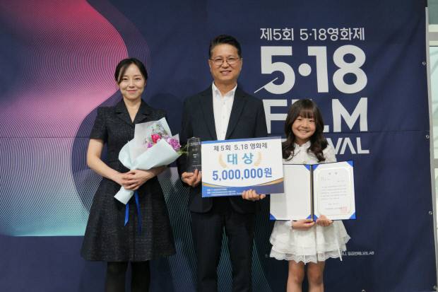 5·18기록관이 제작한 단편영화 ‘오월’의 배우 김보배(왼쪽부터, 민서 역), 감독 방성주, 아역 배우 이유주(은지 역) 양이 제 5회 5·18 영화제 대상을 수상하고 기념촬영을 하고 있다. <광주시 제공>