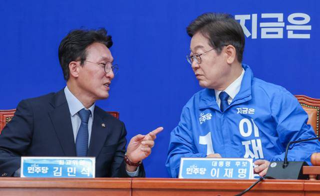 이재명 더불어민주당 대선 후보가 지난달 28일 서울 여의도 국회에서 열린 최고위원회의에 참석해 김민석 최고위원과 대화하고 있다. 뉴스1