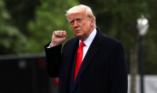 도널드 트럼프 미국 대통령이 22일 백악관을 떠나며 기자들을 향해 주먹을 들어 보이고 있다. 워싱턴/로이터 연합뉴스