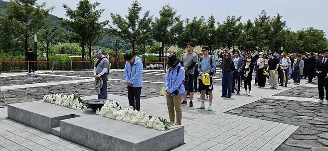 참배객들이 노무현 전 대통령 묘역 앞에 줄을 서서 헌화하고 있다.