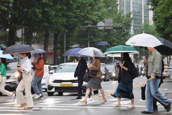 지난 15일 서울 광화문 부근에서 시민들이 우산을 쓰고 이동하고 있다. 〈사진=연합뉴스〉