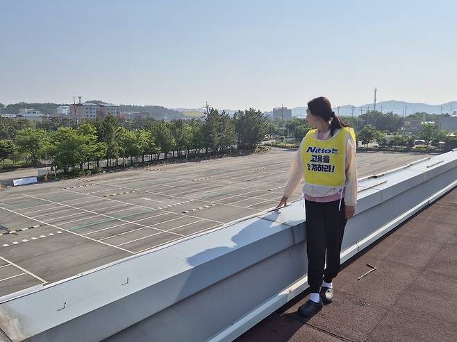 고공농성 500일을 열흘 앞둔 2025년 5월11일, 박정혜 금속노조 한국옵티칼하이테크지회 수석부지회장이 텅 빈 주차장을 내려다보고 있다. 신다은 기자