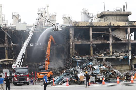 지난 22일 광주 광산구 금호타이어 광주공장에서 수습당국이 중장비를 이용해 불이 난 건물을 철거하고 있다. 연합뉴스