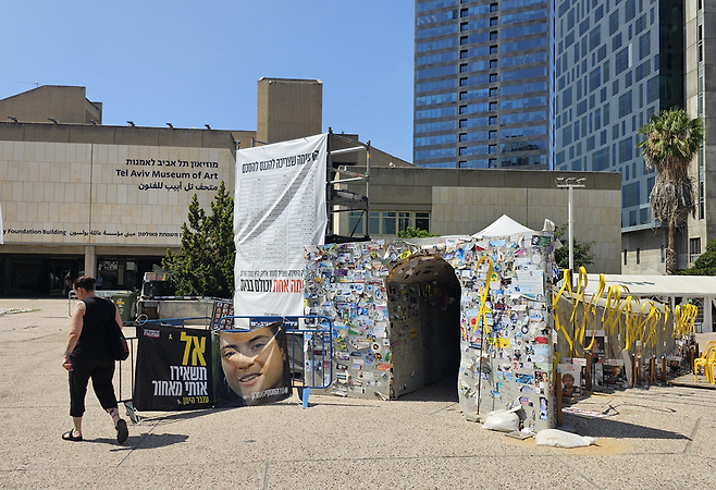 한 시민이 22일(현지시간) 이스라엘 텔아비브 인질광장에 설치된 하마스 터널 조형물 옆을 지나가고 있다. 김이현 기자