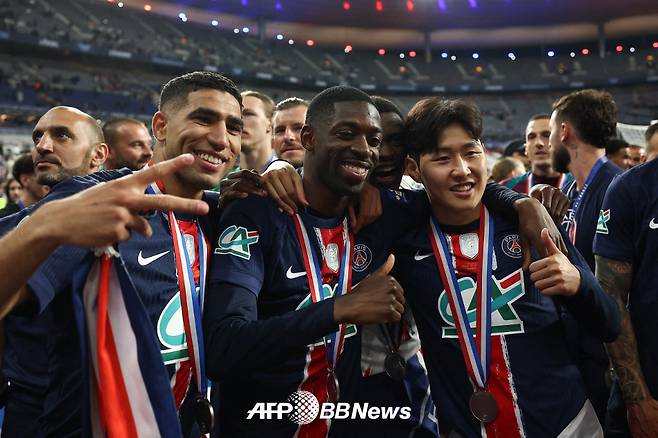 파리 생제르맹 이강인(오른쪽)이 25일 2024~2025 프랑스 쿠프 드 프랑스 우승 메달을 목에 건 채 우스만 뎀벨레 등 동료들과 함께 기념사진을 찍고 있다. /AFPBBNews=뉴스1