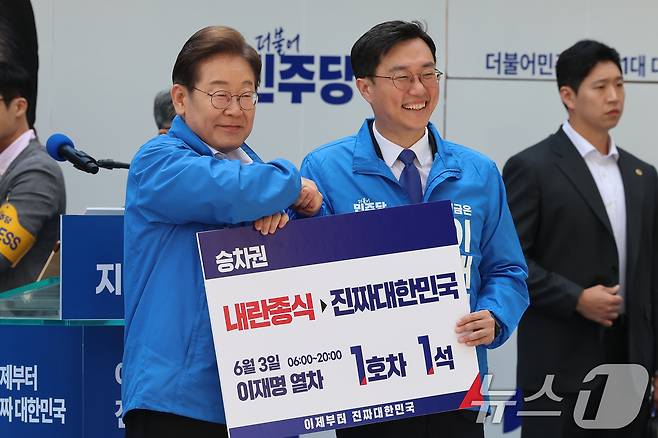 이재명 더불어민주당 대통령 후보가 19일 서울 용산구 용산역 광장에서 열린 집중유세에서 장경태 의원으로부터 이재명 열차 승차권을 받은 뒤 기념촬영을 하고 있다. (공동취재) 2025.5.19/뉴스1 ⓒ News1 안은나 기자