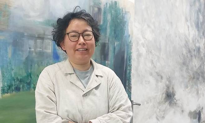 지난 25일 오후 서울 낙원동 디피 전시장에서 만난 박세진 작가. 그의 뒤로 전시 공간의 남향 벽면에 얼룩을 남기듯 작업한 신작 벽화 작업과 전시장 인근의 실버극장 풍경을 담은 이동식 회화가 겹쳐서 보인다. 노형석 기자