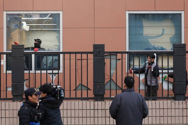 내란죄 피의자 윤석열 대통령의 구속 영장이 발부되자 윤 대통령의 지지자들이 서울 마포구 서울서부지법에 난입해 기물과 유리창 등을 파손한 1월19일 오후 건설업자가 깨진 창문의 유리를 제거하고 있다. 김영원 기자 forever@hani.co.kr