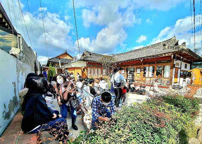 황남동 황리단길 일대 한옥 카페 앞에서 관광객들이 따뜻한 봄볕을 즐기고 있다. 고도 이미지 찾기 사업의 일환으로 조성된 전통 한옥 공간은 지역 청년 창업의 기반이자, 경주의 역사문화경관을 현대적으로 해석한 대표 사례로 손꼽힌다. 경주시 제공