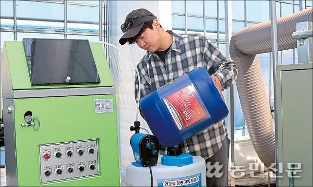 충남 논산시 광석면 율리에서 ‘킹스베리’ 딸기를 재배하는 손국현씨가 정량 펌프에 오스템바이오 소독제 ‘엔도씰’을 넣고 있다. 손씨는 더운 5월에도 고품질 딸기 출하를 이어가고 있다.