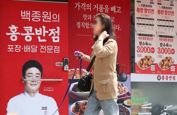 가맹점 지원 할인 행사 진행하는 더본코리아 - 13일 서울 시내 한 홍콩반점0410 매장에 할인 안내문과 백 대표 사진이 붙어 있다. 2025.5.13 연합뉴스