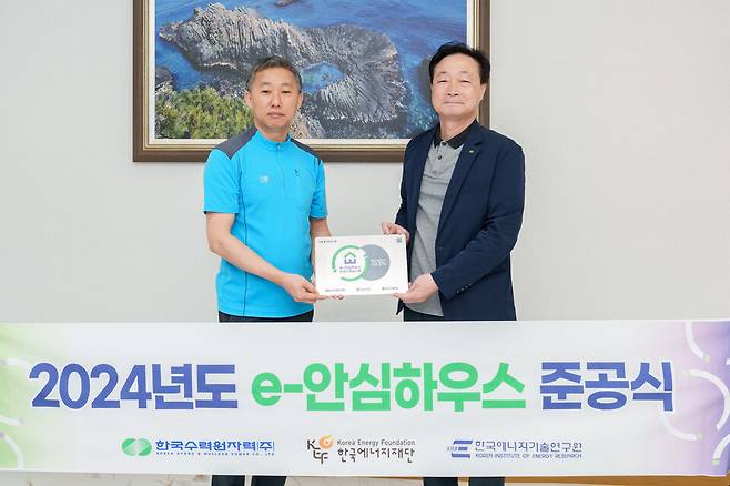 22일 월성원자력 정원호 본부장(오른쪽)이 'e-안심하우스' 준공식에서 '무료급식마당 이웃집'의 신대명 국장과 함께 'e-안심하우스'의 현판을 들고 기념촬영을 하고 있다. ⓒ월성원자력