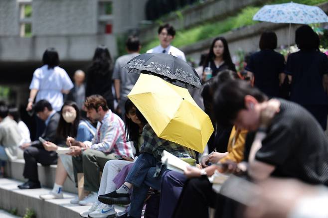 26일 오후 서울 청계광장에서 겉옷을 벗거나 양산을 쓴 시민들이 올해 마지막 봄을 즐기고 있다. (사진=뉴스1)