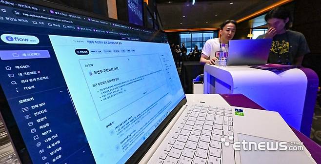 플로우 10주년: flow X Day가 27일 서울 여의도 콘래드호텔에서 열렸다. 참석자가 플로우 AI 에이전트 '메이트X'를 살펴보고 있다. 이동근기자 foto@etnews.com