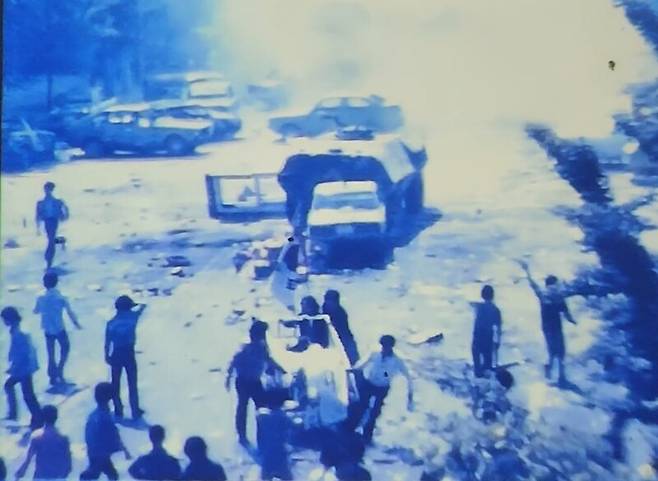 1980년 5월21일 광주 금남로에서 공수부대가 최루탄을 쏘자 시민들이 전날 계엄군의 집단 발포로 숨진 주검이 실린 손수레를 끌고 도로를 벗어나고 있다. 5·18기록관 영상 갈무리