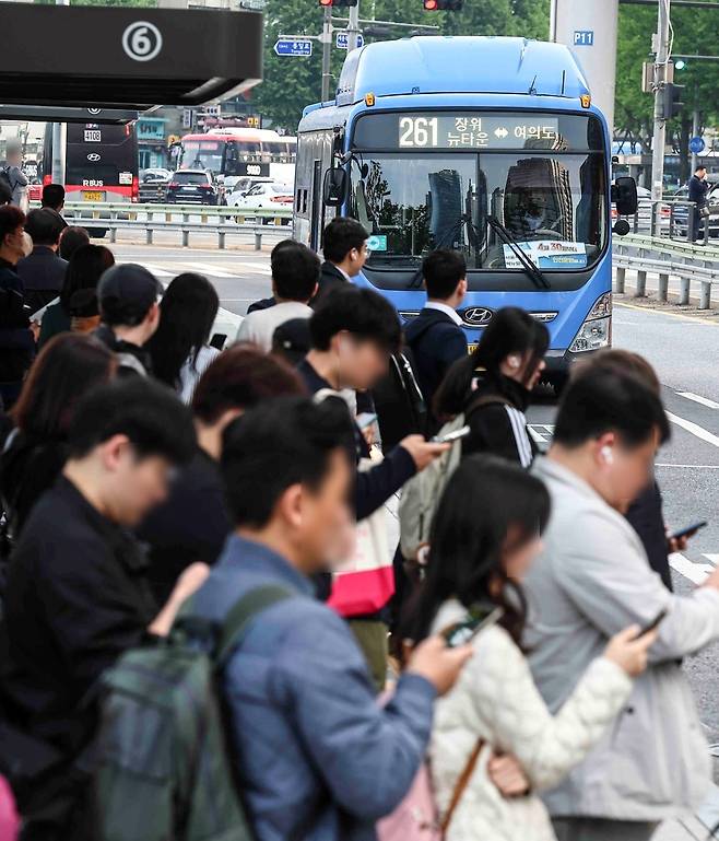 Commuters wait at a bus stop in Seoul on Apr. 30. (Yonhap)
