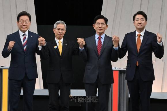 이재명 더불어민주당(왼쪽부터)·권영국 민주노동당·김문수 국민의힘·이준석 개혁신당 대선 후보가 27일 서울 마포구 상암동 MBC 스튜디오에서 진행된 3차 TV 토론회에 앞서 손을 맞잡고 사진을 찍고 있다. 2025.5.27 국회사진기자단