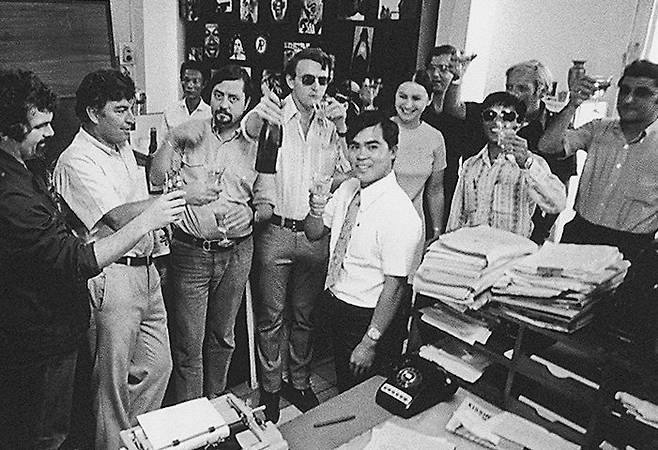 1973년 5월, 정확한 날짜는 알려지지 않은 이 사진은 AP통신 사이공(현 호찌민) 지국 직원들이 닉 우트의 퓰리처상 수상 소식을 축하하는 모습을 담고 있다. 가운데 반팔 셔츠에 넥타이를 매고 있는 인물이 닉 우트이며, 그의 옆에 선글라스를 쓰고 샴페인 병을 든 사람이 칼 로빈슨이다. 왼쪽에서 두 번째가 호르스트 파스다. AP 뉴시스