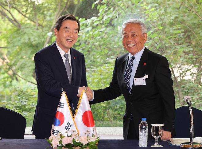 한국 측 단장인 김윤 삼양홀딩스 회장(한일경제협회 회장)과 일본 측 단장인 아소 유타카 일한경제협회 부회장이 악수를 하며 기념촬영을 하고 있다 . 이충우 기자