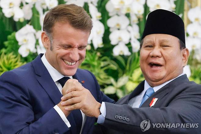 인도네시아·프랑스 정상회담 (자카르타 AFP=연합뉴스) 28일 인도네시아·프랑스 정상회담 후 인도네시아 자카르타 대통령궁에서 열린 기자회견에서 에마뉘엘 마크롱(왼쪽) 프랑스 대통령과 프라보워 수비안토 인도네시아 대통령이 손을 맞잡고 있다. 2025.5.28. photo@yna.co.kr