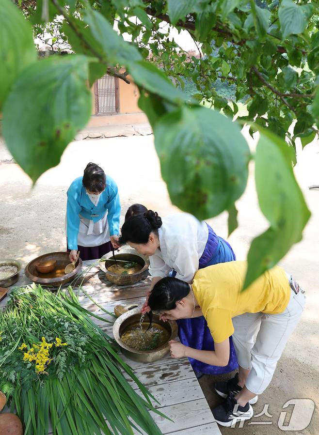 단오(음력 5월5일)를 이틀 앞둔 29일 경기 용인시 기흥구 한국민속촌에서 관광객들이 창포물에 머리 감기 체험을 하고 있다. 2025.5.29/뉴스1 ⓒ News1 김영운 기자