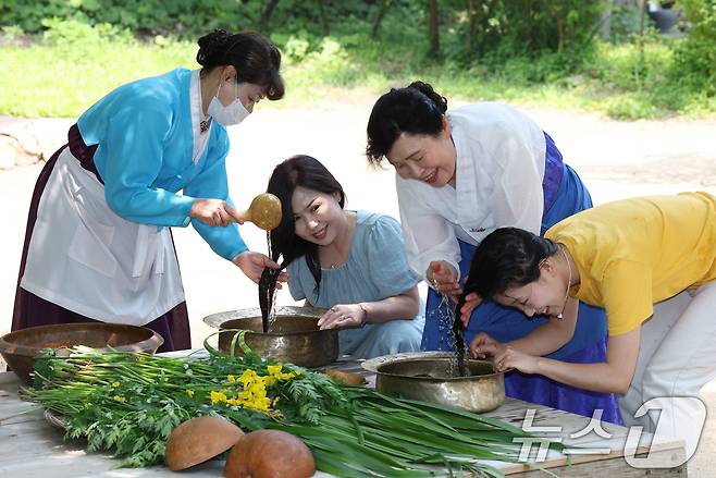 단오(음력 5월5일)를 이틀 앞둔 29일 경기 용인시 기흥구 한국민속촌에서 관광객들이 창포물에 머리 감기 체험을 하고 있다. 2025.5.29/뉴스1 ⓒ News1 김영운 기자