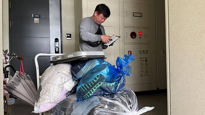 지난 15일 오전 헌옷 방문수거 업체를 운영하는 김영선씨가 헌옷을 봉지에 나눠 담고 옷값을 책정하고 있다./김도균 기자