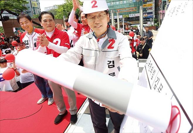 김문수 국민의힘 대선 후보(오른쪽)가 28일 경남 창원 상남동 분수광장 유세에서 투표를 독려하는 차원에서 자신의 이름이 인쇄된 대형 투표용지에 도장을 찍고 있다. /연합뉴스