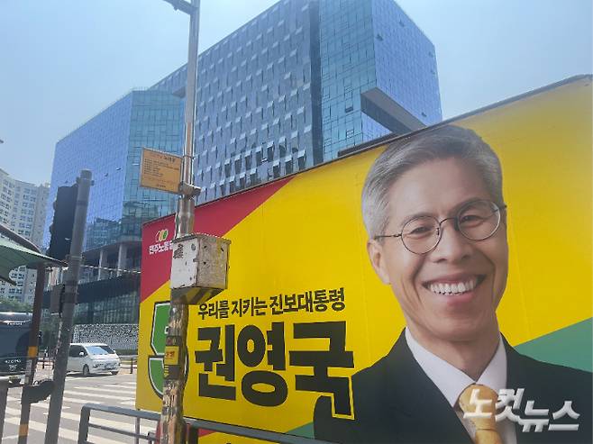 판교역에서 유세 중인 권영국 후보의 유세차 뒤로 대형빌딩이 위치해 있다. 판교신도시는 전문가들이 손에 꼽는 신도시 계획사업의 우수 사례이다. 박준현 기자