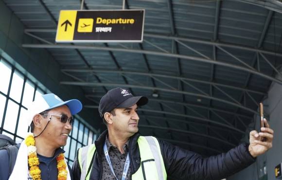 지난달 20일 에베레스트 출발에 앞서 카트만두 공항에서 한 남성과 기념 촬영을 하는 카미 리타(왼쪽). AP 연합뉴스 자료사진