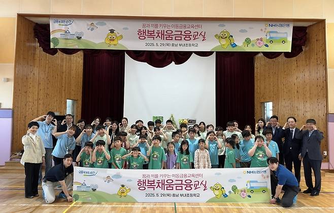 29일 최동하 수석부행장(뒷줄 오른쪽 세 번째) 및 농협은행 임직원, N돌핀 단원들이 충남 서천군 부내초등학교를 찾아 이동금융교육을 실시했다. 김흥집 충청남도서천교육지원청 교육장(뒷줄 오른쪽 두 번째), 최창호 서천농협 조합장(뒷줄 오른쪽 첫번째), 김미란 부내초등학교 교장(뒷줄 왼쪽 첫번째)