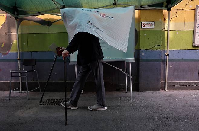 몸이 불편한 유권자가 5월29일 오전 서울 중구 소공동주민센터 앞에 마련된 기표소에서 투표하고 있다. 투표 장소는 4층이나, 몸이 불편한 분들을 위해 따로 건물 들머리에 기표소를 마련했다. 이종근 선임기자