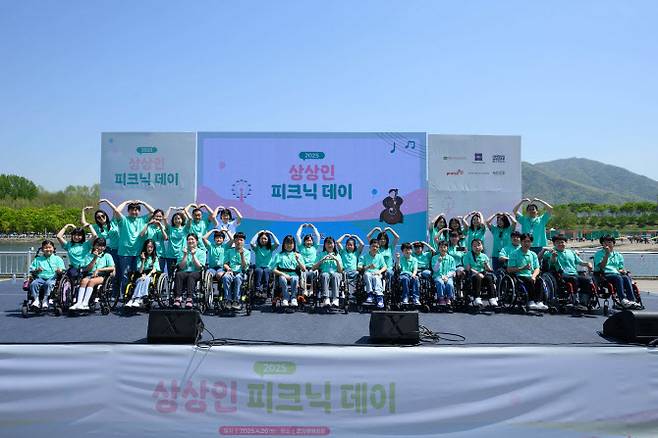 상상인그룹이 지난 26일 경기도 하남 미사경정공원에서 개최한 ‘2025 상상인 피크닉 데이’에서 ‘상상휠하모니 오케스트라’ 단원들이 축하공연을 마치고 기념촬영을 하고 있다. (사진=상상인그룹)