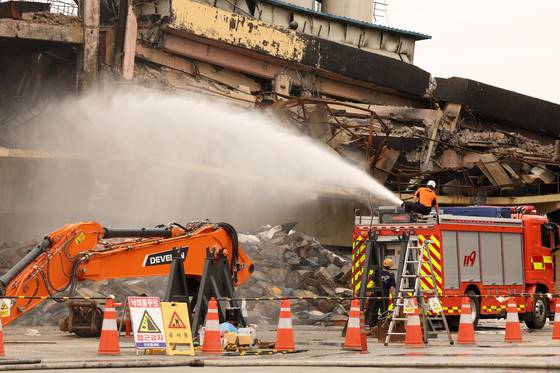 지난 22일 오전 광주 광산구 소촌동 금호타이어 광주공장 화재 현장에서 건물 해체 작업 중 먼지 날림을 최소화하기 위한 분무가 이뤄지고 있다. 뉴스1