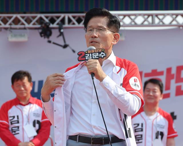 ▲국민의힘 김문수 대선 후보가 29일 경기 안산시 안산문화광장에서 열린 유세에서 방탄복을 착용하는 더불어민주당 이재명 후보를 비판하며 자신의 겉옷을 벗어보이고 있다. ⓒ연합뉴스