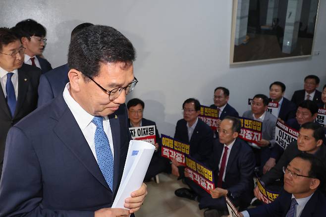 7일 국회 행정안전위원회 신정훈 위원장이 공직선거법 개정안 단독 처리에 반대하며 구호를 외치는 국민의힘 의원들 앞을 지나 행안위 회의장으로 들어가고 있다. 연합뉴스