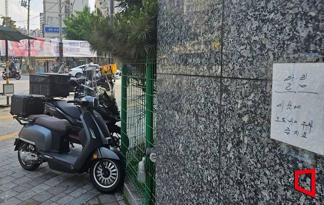 1일 서울 중구 황학동에서 '오토바이 주차 금지' 안내가 붙은 건물 앞에 오토바이가 주차돼 있다. 박승욱 기자