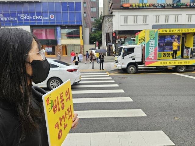 성폭력 피해자 이아무개씨가 2일 오전 서울 강남역 인근에서 연설을 하고 있는 권영국 민주노동당 대통령 후보를 바라보고 있다. 류석우 기자