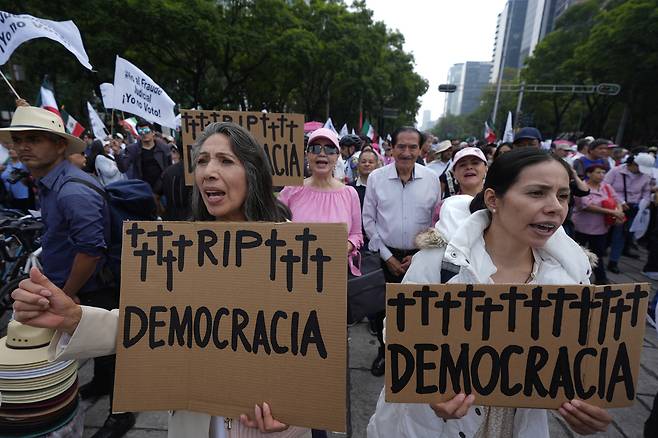 시위대가 1일(현지시간) 멕시코시티에서 열린 법관 직선제 반대 시위에서 ‘민주주의의 명복을 빈다’는 손팻말을 들고 구호를 외치고 있다. AP연합뉴스