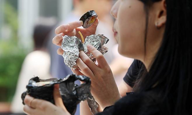 제21대 대통령선거 사전 투표일인 5월 30일 서울 강남구 역삼1동주민센터에 마련된 사전투표소에서 유권자가 투표줄을 기다리며 점심을 김밥으로 해결하고 있다. 연합뉴스