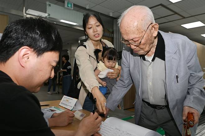 일제강점기 당시 태어난 백삼봉(103) 어르신이 제21대 대통령 선거 본투표가 치러지는 3일 오전 광주 남구 진월행정복지센터에 마련된 진월동 제1투표소에서 손녀의 도움을 받으며 신원을 확인받고 있다. /뉴시스