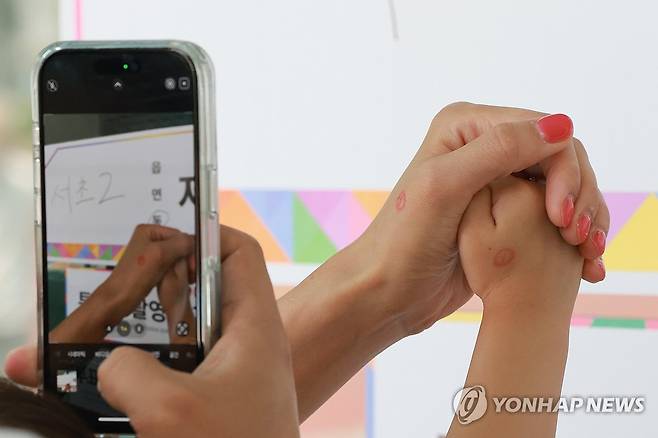 아이와 함께 투표 인증 (서울=연합뉴스) 신현우 기자 = 제21대 대통령 선거일인 3일 서울 서초구 서울중학교에 마련된 서초2동제4투표소에서 유권자가 아이와 함께 투표 인증 사진을 촬영하고 있다. 2025.6.3 nowwego@yna.co.kr