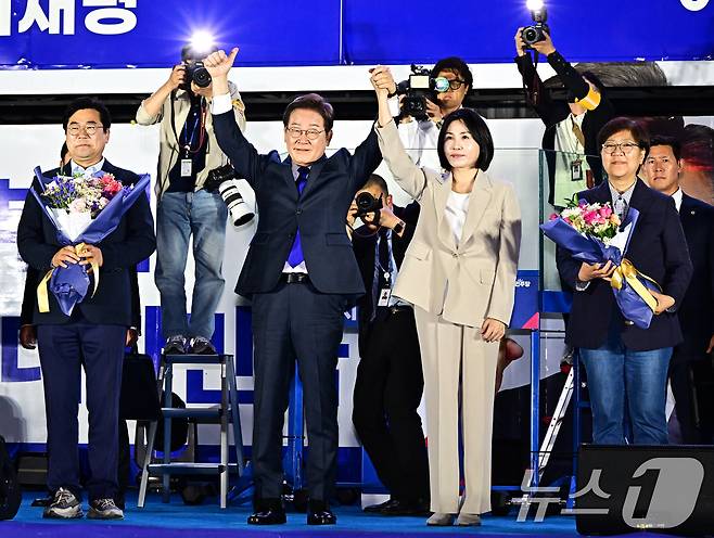 제21대 대통령 선거에서 당선이 확실해진 이재명 더불어민주당 후보가 김혜경 여사와 4일 오전 서울 여의도 국회 앞에 마련된 개표방송 야외 무대에 올라 인사하고 있다. (공동취재) 2025.6.4/뉴스1 ⓒ News1 안은나 기자